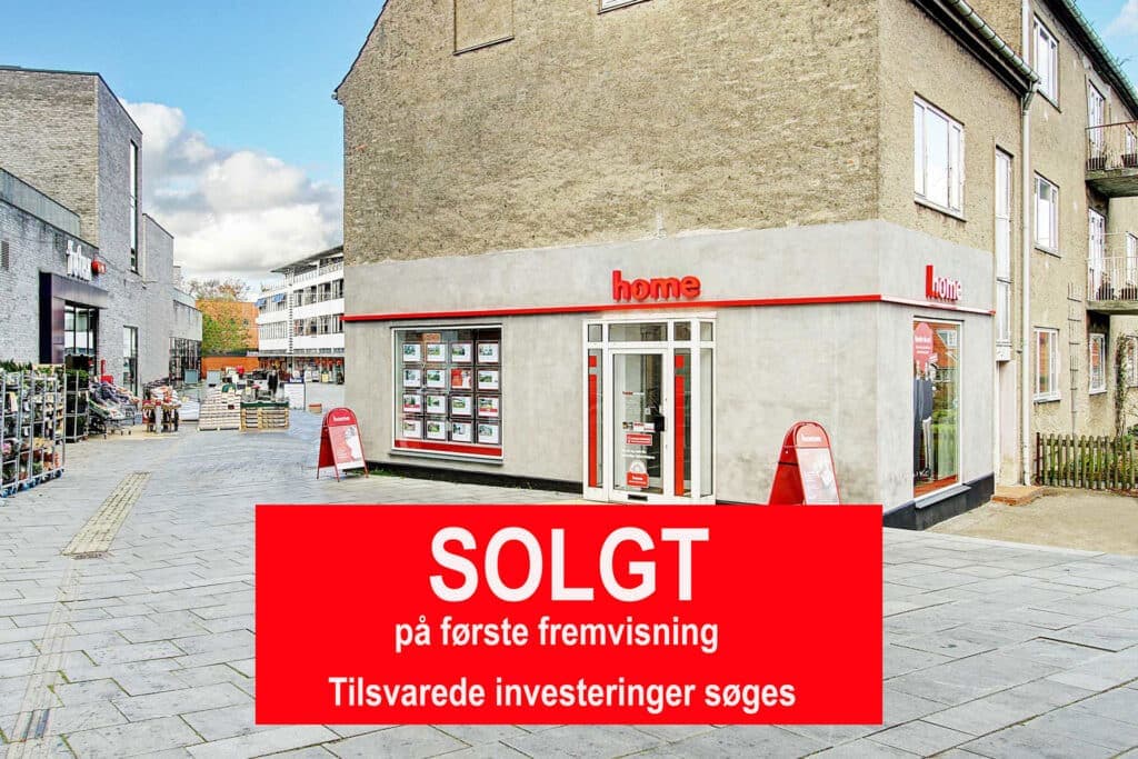 Erhvervsejendommen på Teglporten i Birkerød set fra gadehjørnet, med butiksfacade i stueetagen. Rødt solgt-banner er lagt oven på fotoet.